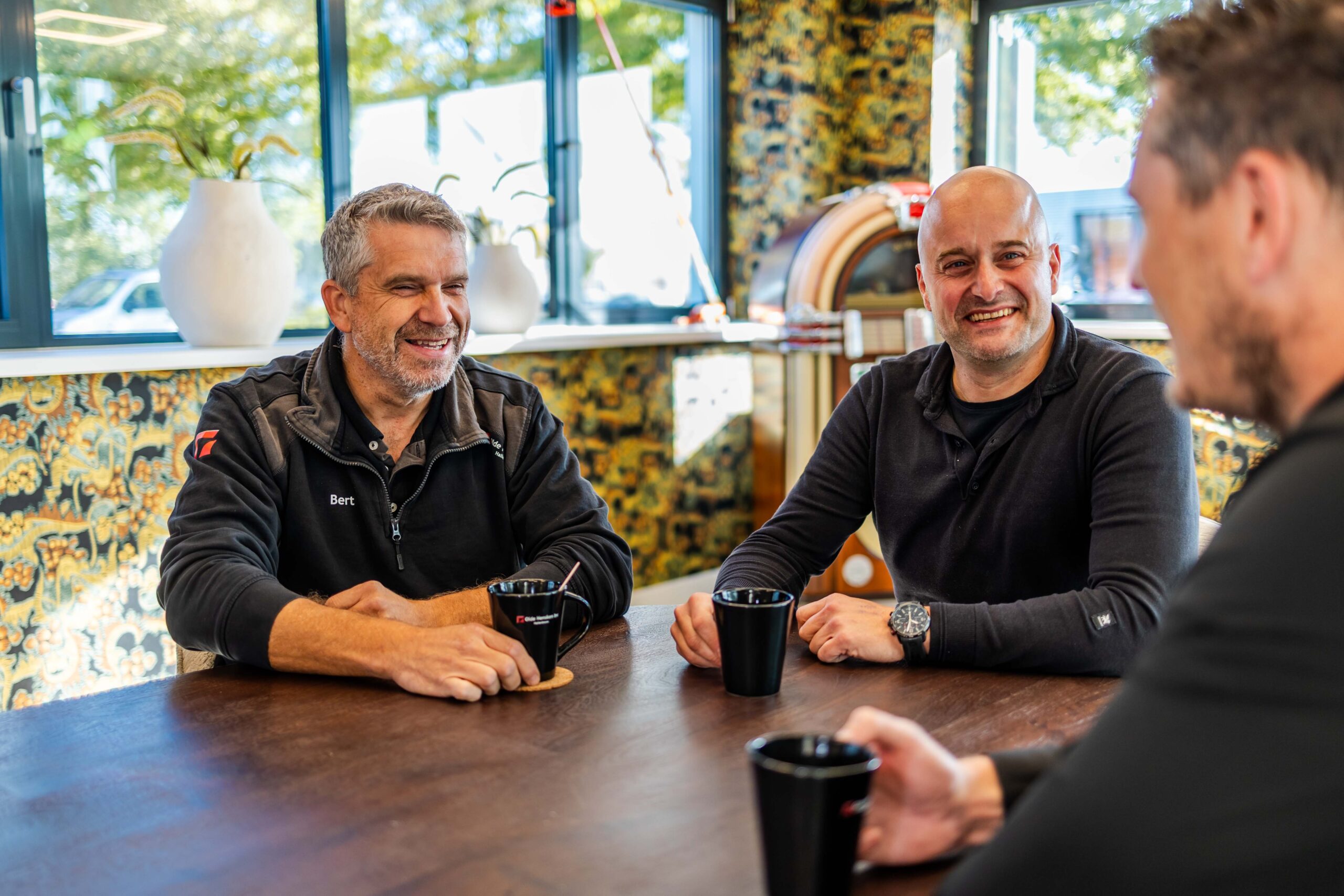 Team van Olde Hensken Hallenbouw in Almelo drinkt koffie en bespreekt projecten – persoonlijk contact en samenwerking.